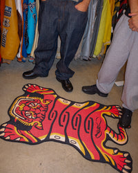 Orange Tuned Tiger rug next to two people standing, shown for size